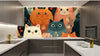 Mise en scène d'intérieur bohème avec le Papier Peint Chat Floral Vintage Bohème posé sur un mur en salon, associé à des meubles en rotin, des plantes suspendues et une lumière dorée tamisée