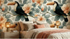 Vue panoramique du Papier Peint Toucan Poétique aux Feuilles Vertes et Dorées posé sur un mur entier, montrant la répétition harmonieuse des motifs botaniques tropicaux et des toucans expressifs aux becs colorés