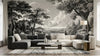 Vue détaillée d'un papier peint panoramique forêt ancienne noir et blanc ornant un salon moderne, avec des branches entrelacées créant une canopée dense et envoûtante