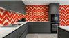 Chambre moderne décorée avec le Papier Peint Rouge Graphique Chevron Berlingot créant un accent mural dynamique aux tons rouge profond et blanc contrasté