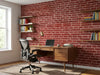 Papier peint brique New York posé dans un bureau avec étagères de livres et fauteuil ergonomique