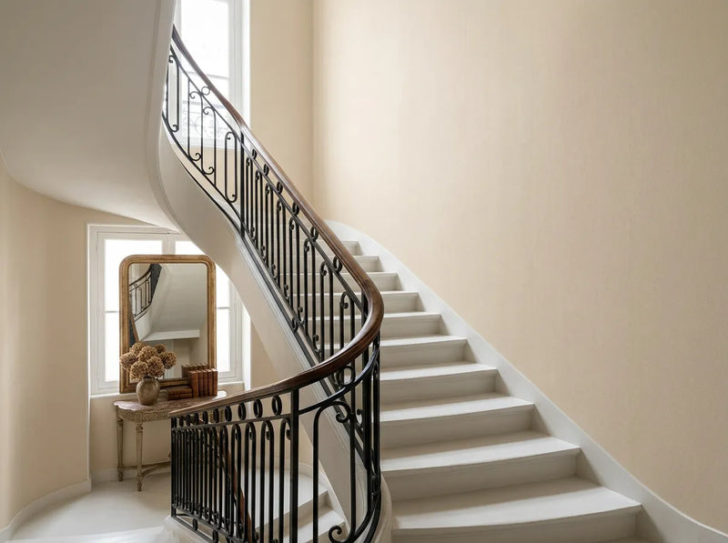Papier peint couloir beige uni posé dans une cage d'escalier classique en colimaçon