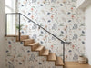 Papier peint couloir fleuri posé le long d'un escalier moderne aux marches en bois clair