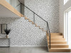 Papier peint couloir noir et blanc à pois posé dans une cage d'escalier moderne aux marches en bois