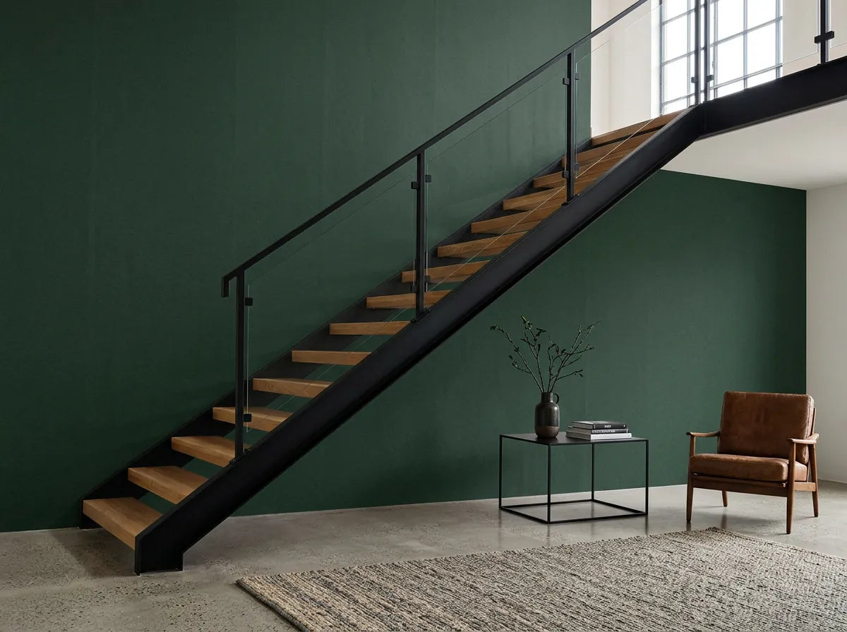 Papier peint couloir vert sapin posé derrière un escalier industriel avec fauteuil en cuir