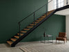 Papier peint couloir vert sapin posé derrière un escalier industriel avec fauteuil en cuir
