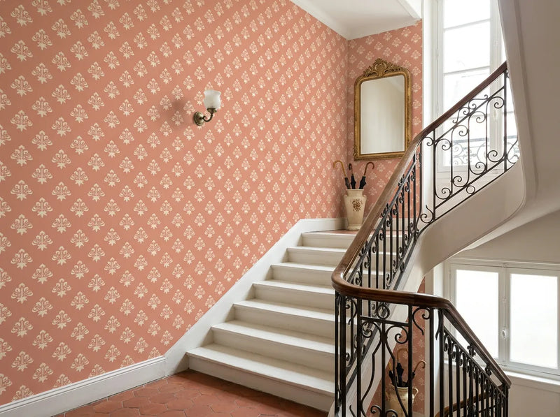 Papier peint couloir vintage corail posé dans une cage d'escalier classique avec rampe en fer forgé
