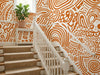 Papier peint ethnique terracotta posé dans l'escalier d'une maison avec tapis d'escalier et rampe blanche