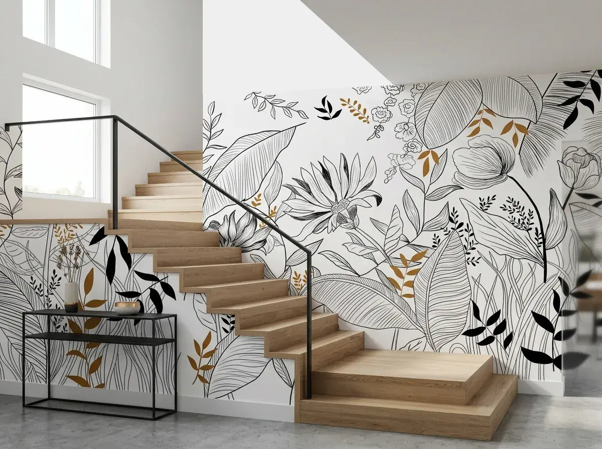 Papier peint feuillage noir, blanc et doré posé dans une cage d'escalier moderne aux marches en chêne