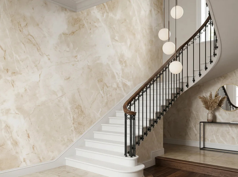 Papier peint marbre beige posé dans une cage d'escalier classique avec rampe en fer forgé et suspensions
