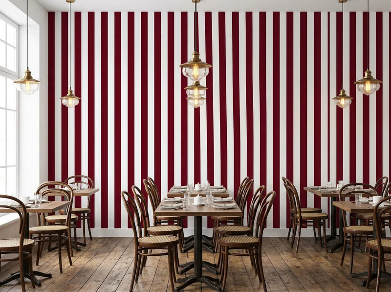 Papier peint rayures bordeaux posé dans un restaurant bistro avec chaises bistrot et suspensions en laiton