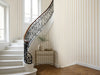 Papier peint rayures couloir beige posé dans une cage d'escalier classique en colimaçon