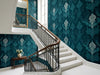 Papier peint vintage bleu canard posé dans une cage d'escalier haussmannienne avec rampe en fer forgé
