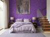 Papier peint violet pailleté posé derrière un lit au linge lilas dans une chambre avec escalier